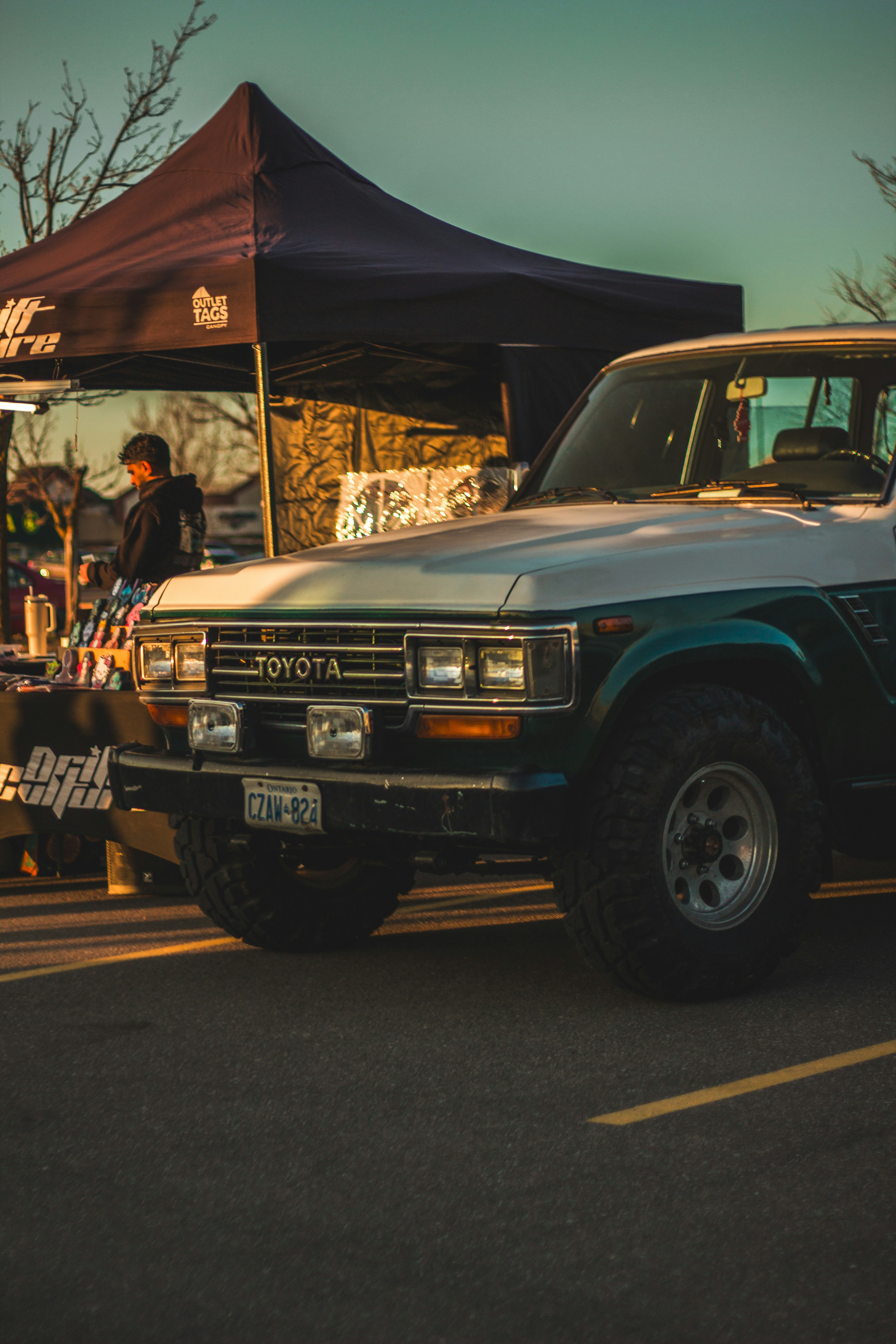 ein Lastwagen, der auf einem Parkplatz neben einem Zelt geparkt ist