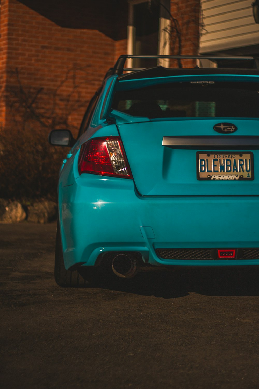 a blue car parked in front of a house