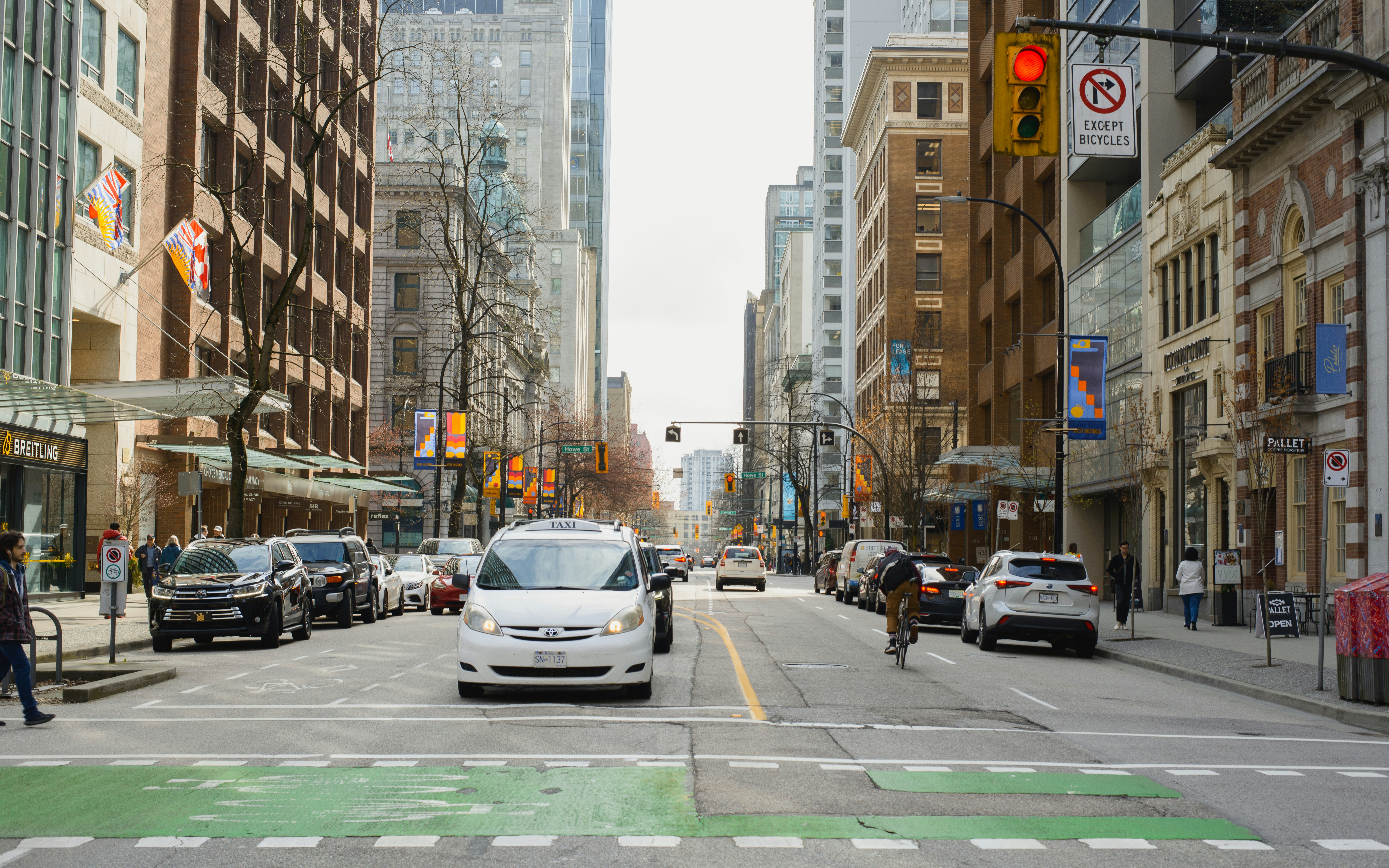 a city street filled with lots of traffic next to tall buildings