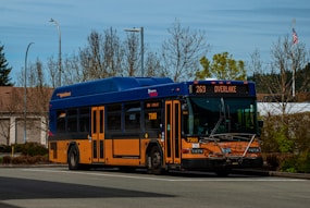 a blue and orange bus driving down a street