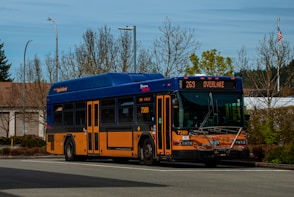 a blue and orange bus driving down a street