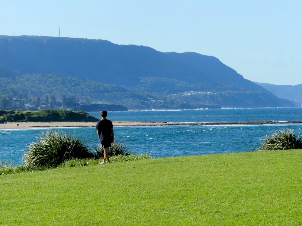 a man standing on top of a lush green field