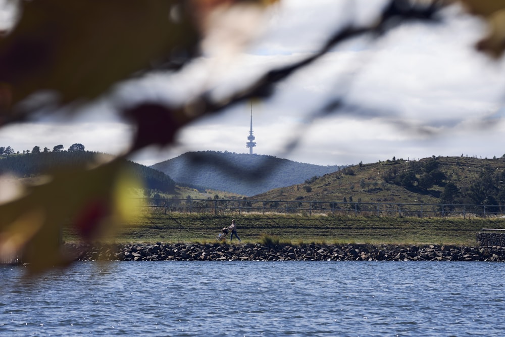 a body of water with a hill in the background