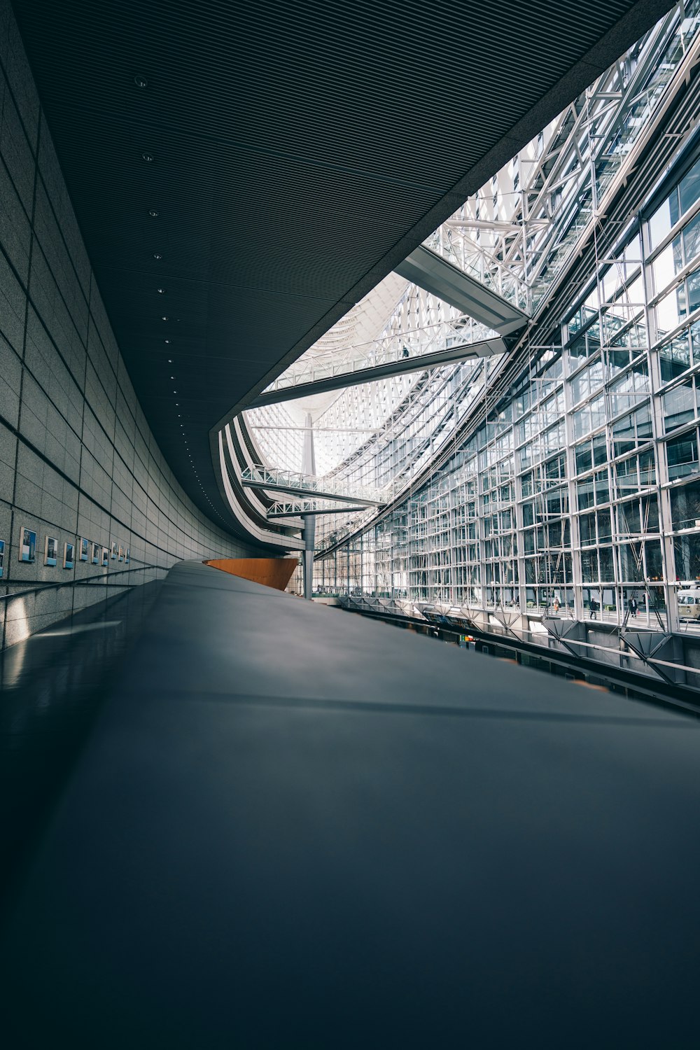 an empty walkway in a large building with lots of windows