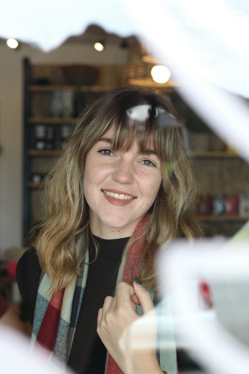 a woman is smiling while looking through a window