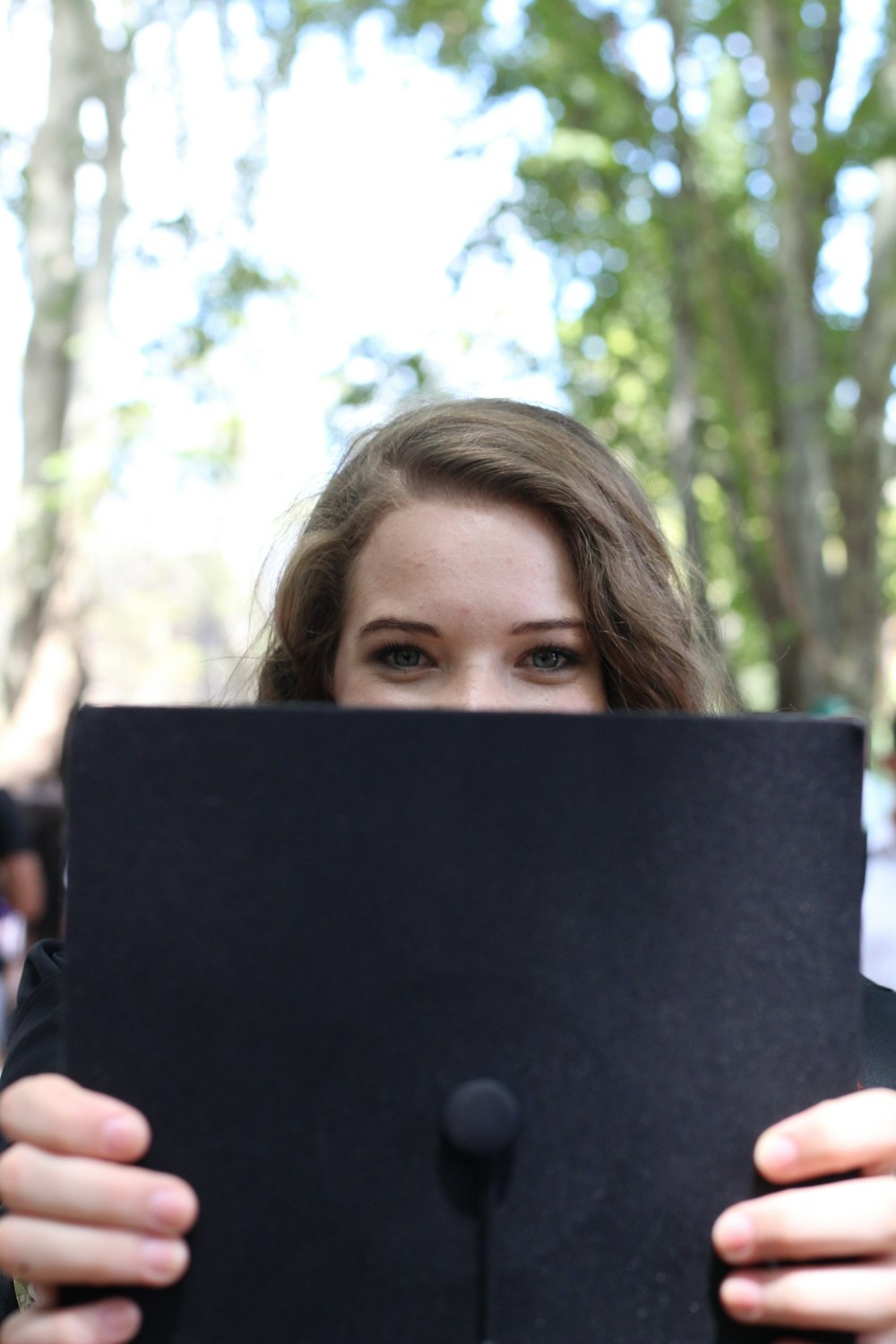 a woman holding up a black piece of paper