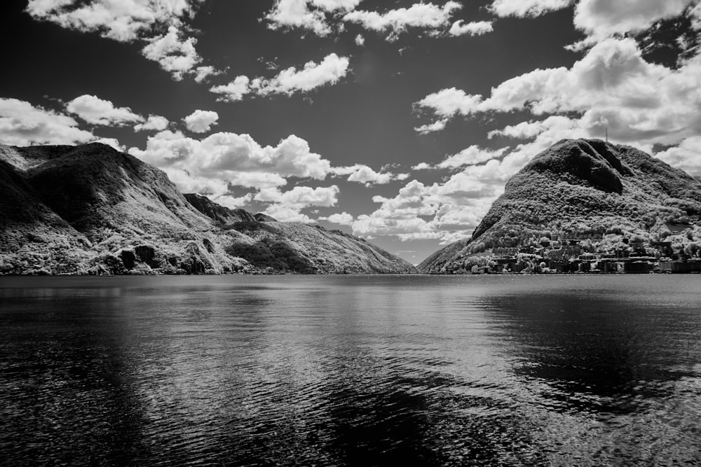 a black and white photo of mountains and water