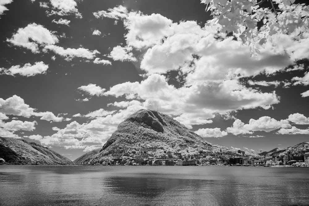 a black and white photo of a lake and mountains