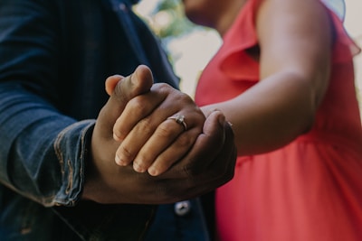 a close up of a person holding the hand of another person
