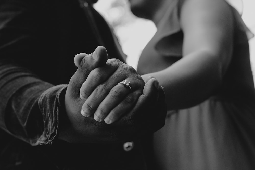 a close up of a person holding the hand of another person