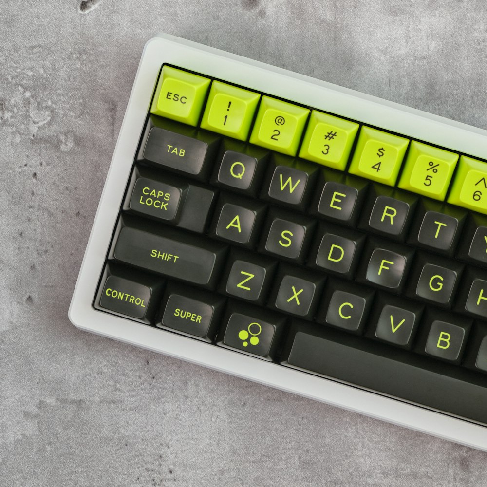 a black and yellow keyboard on a gray surface