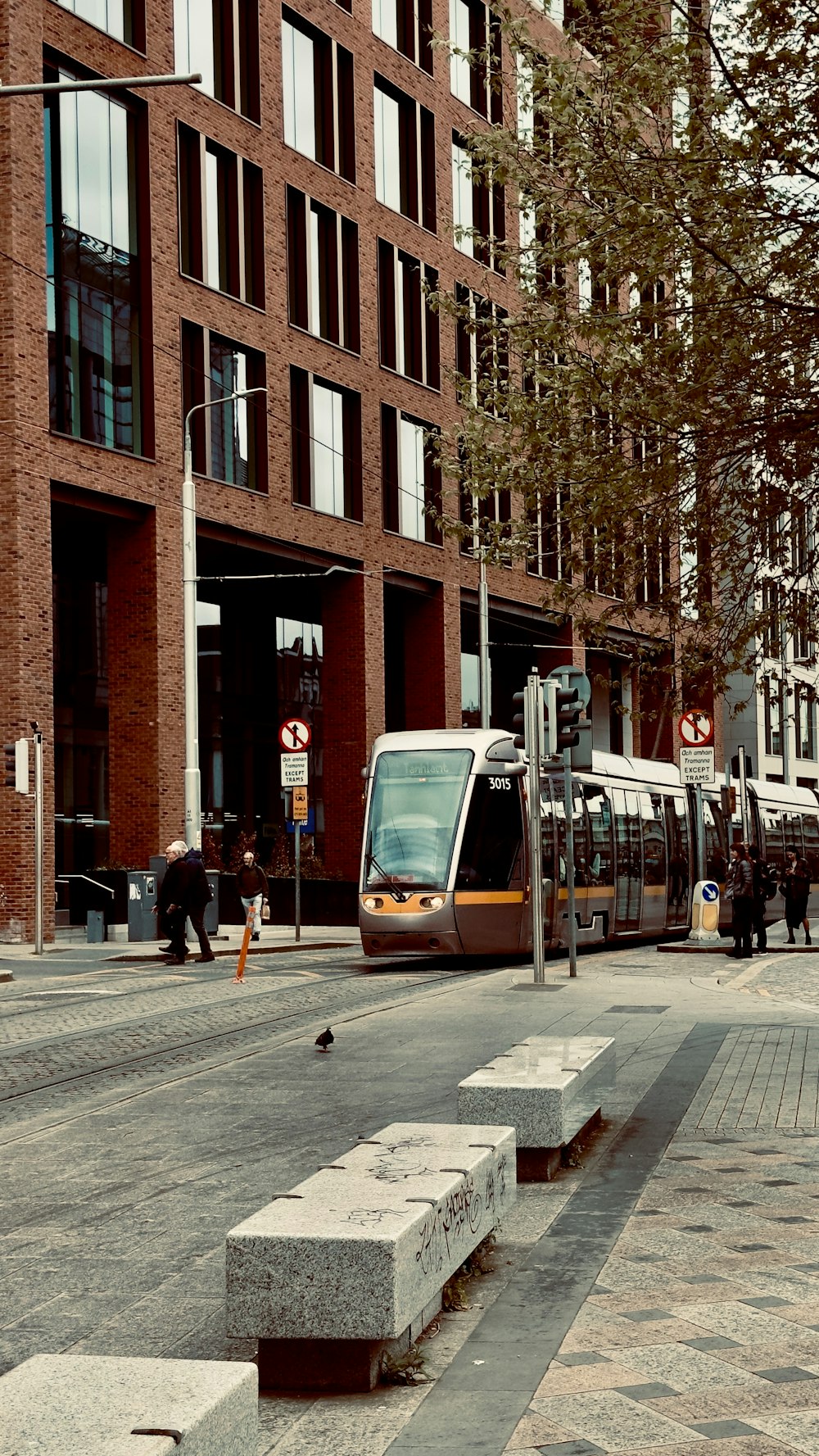 a train on a city street next to a building