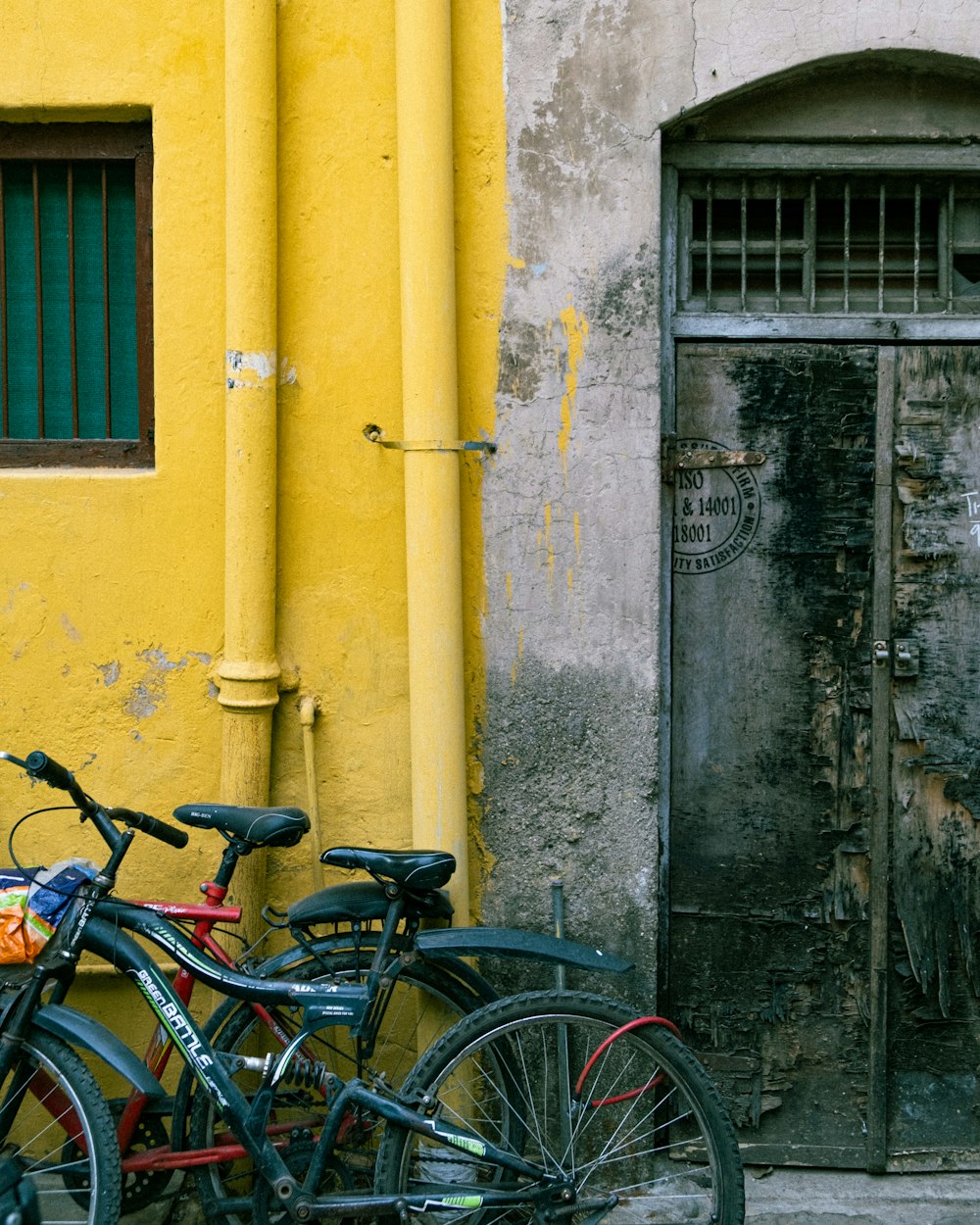 a couple of bikes parked in front of a yellow building