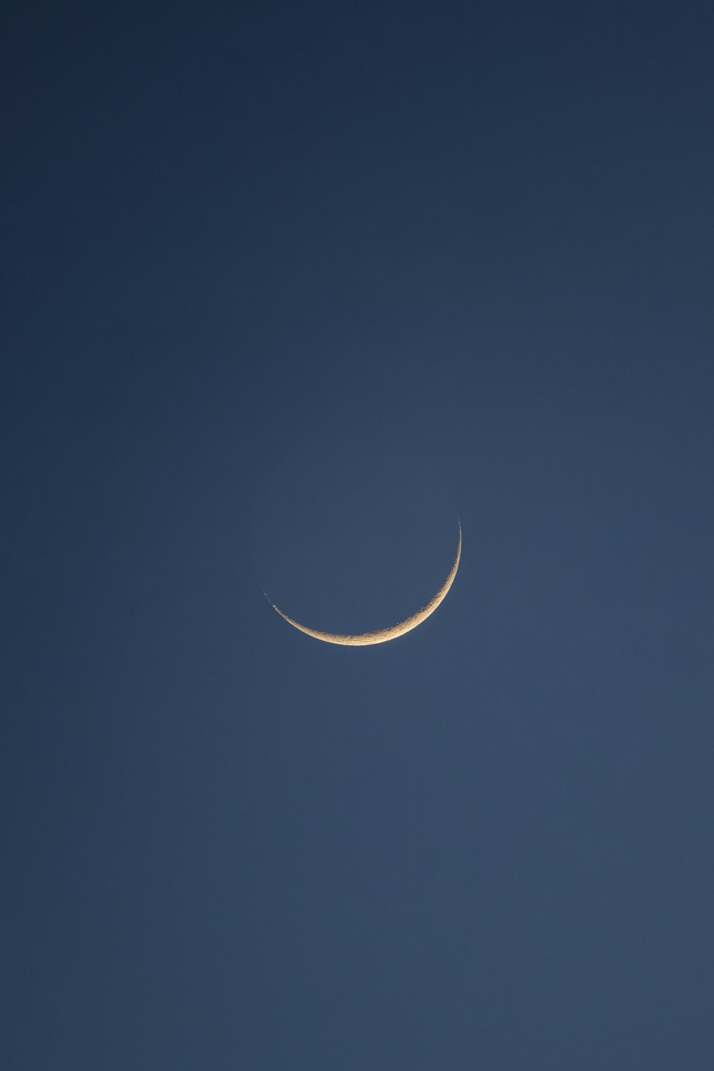 a crescent moon in a clear blue sky