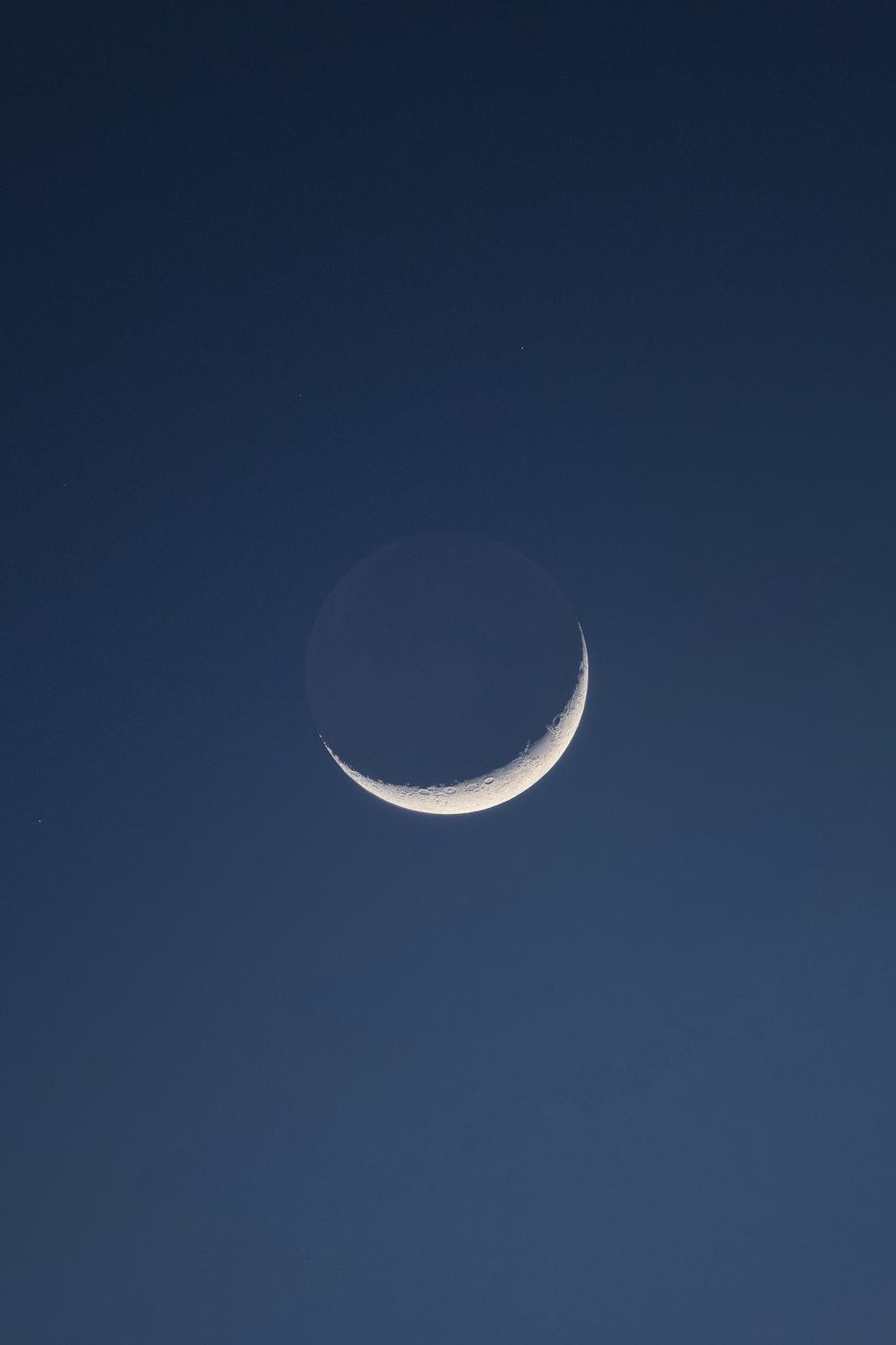 a crescent moon in a clear blue sky