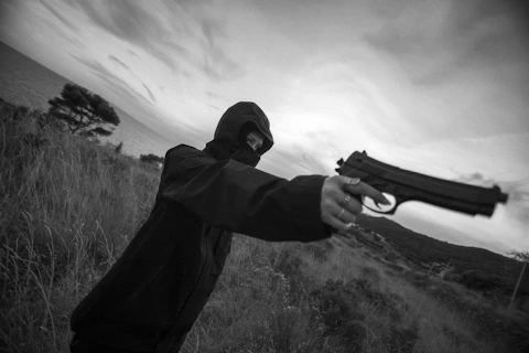 A man holding a gun in a field