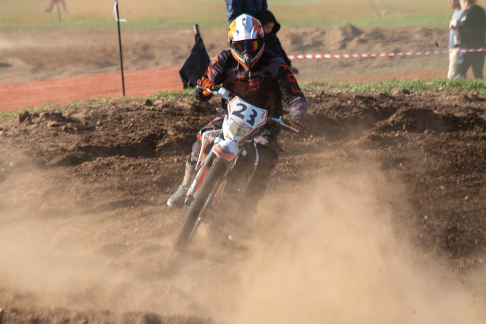 a man riding a dirt bike on top of a dirt field