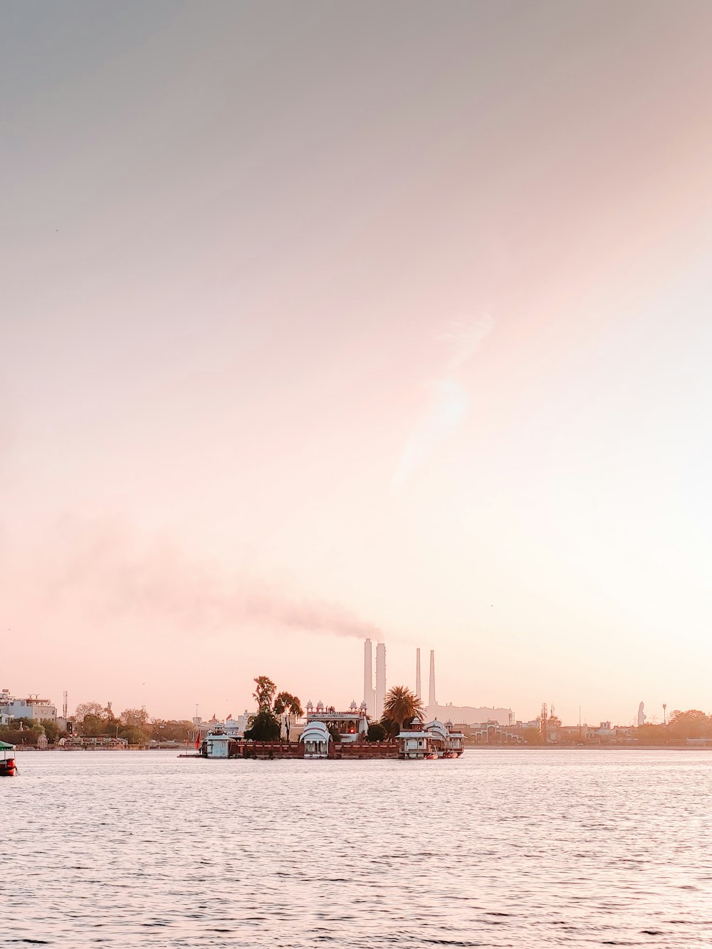 a large body of water with a factory in the background