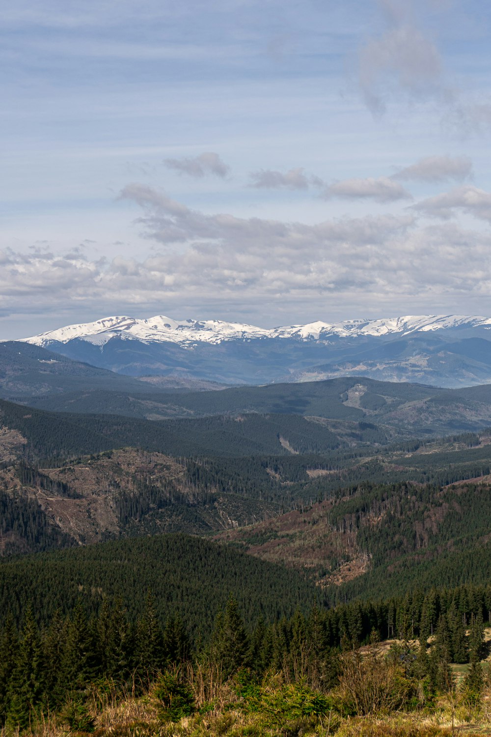 a view of a mountain range with snow capped mountains in the distance