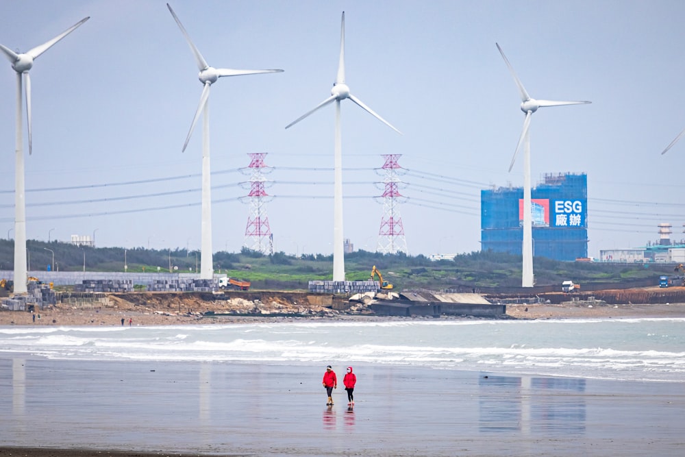 a couple of people standing on top of a beach