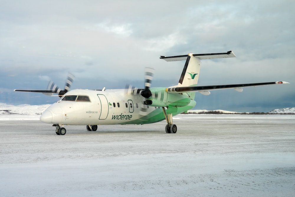 a small plane is sitting on a snowy runway