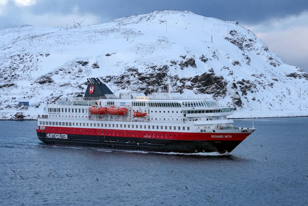 a red and white cruise ship in a body of water