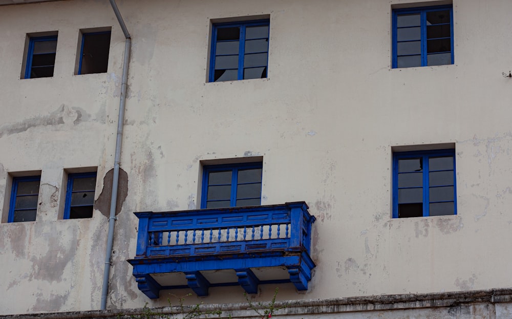 un banco azul sentado frente a un edificio blanco