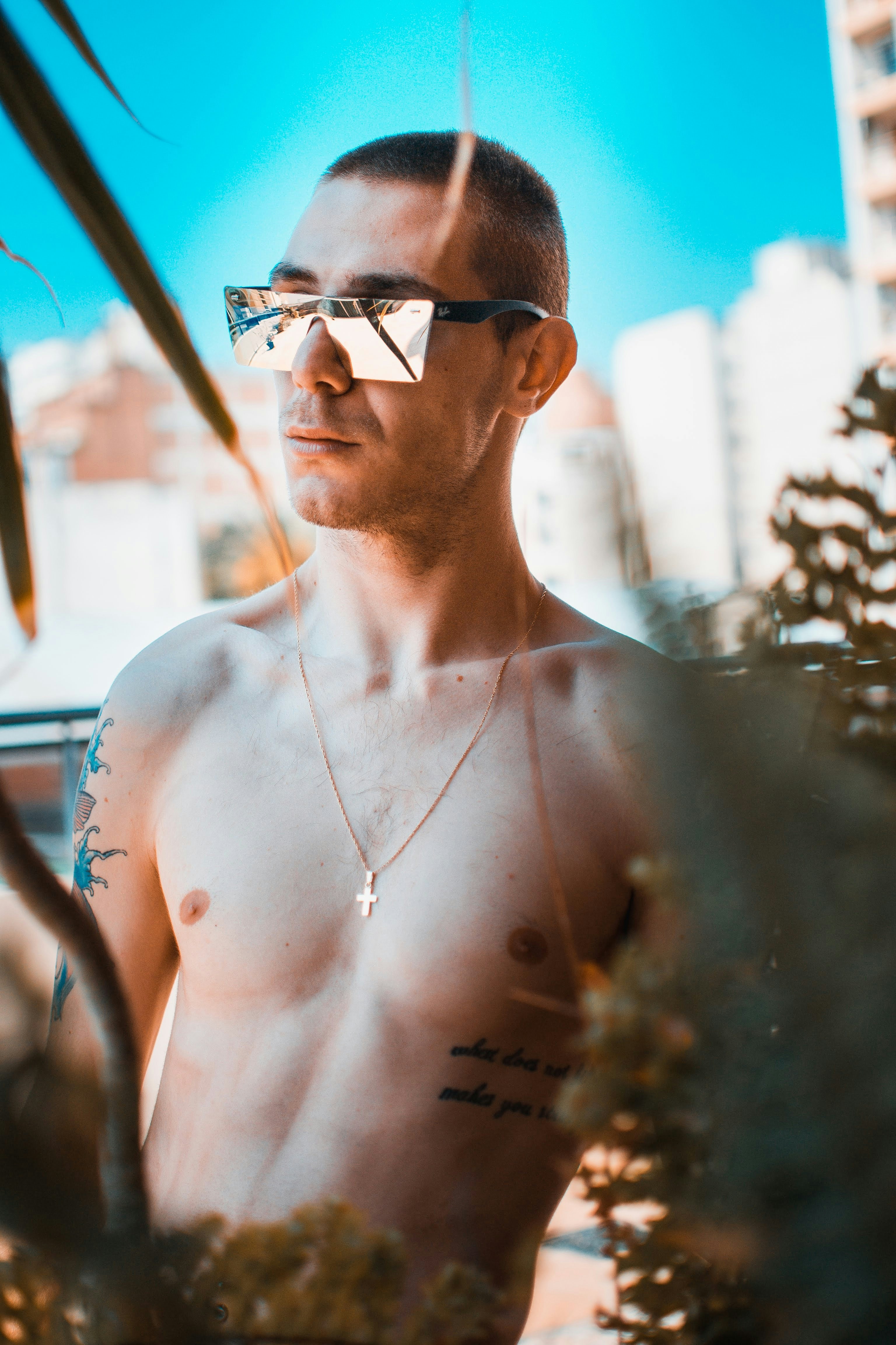 un uomo a torso nudo senza maglietta in piedi davanti a un albero