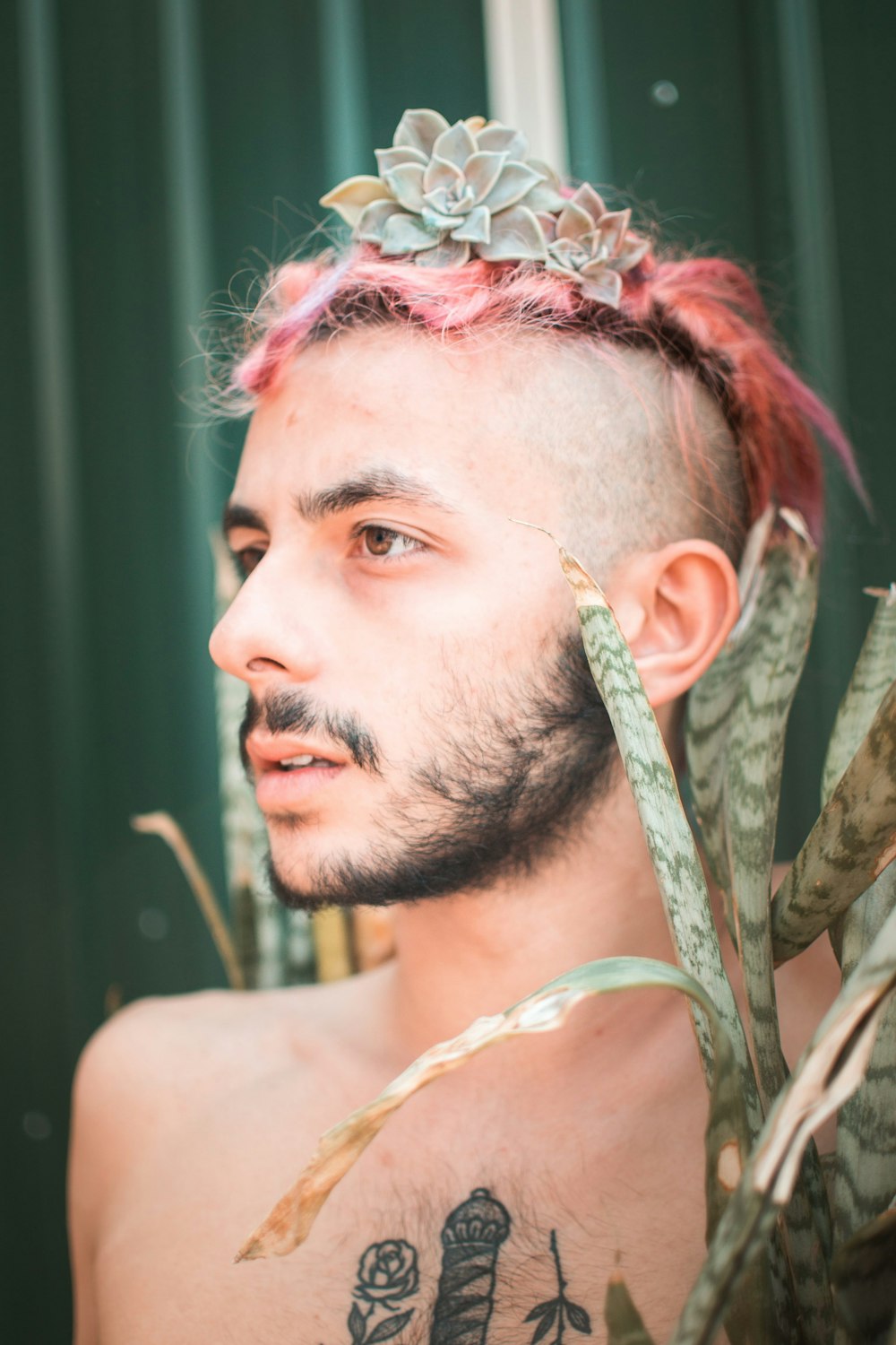 a man with pink hair and a crown on his head