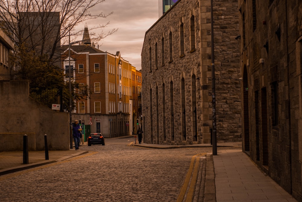 a cobblestone street with a clock tower in the background