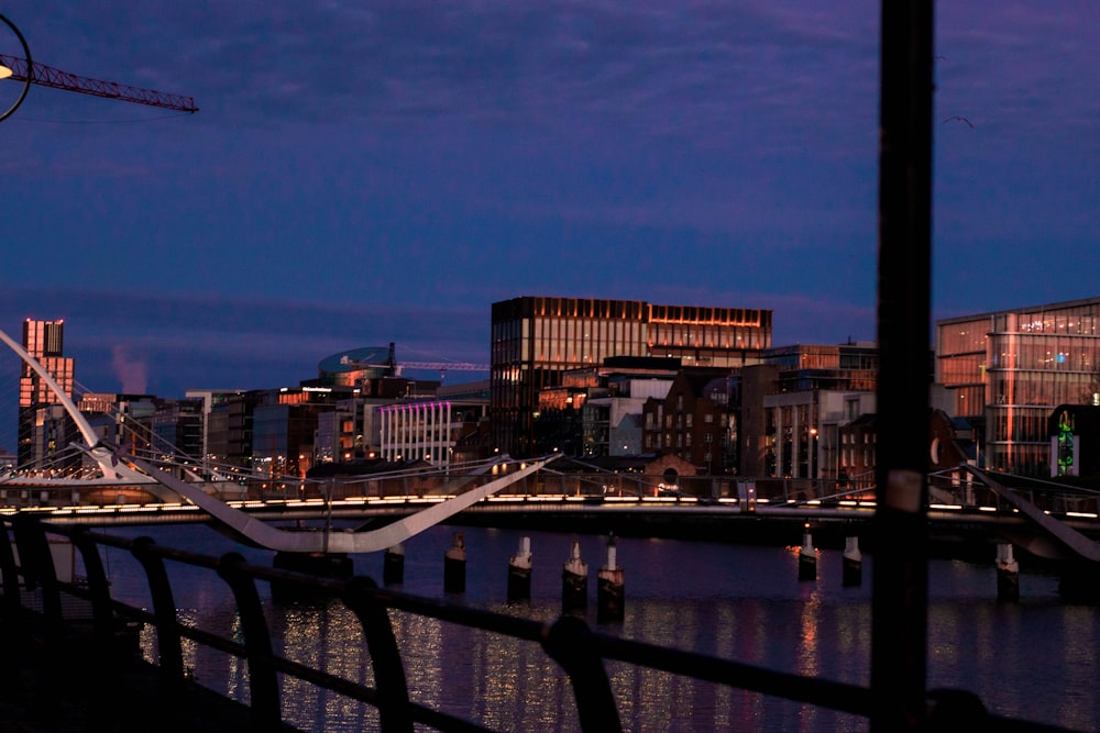 a bridge over a river with a city in the background