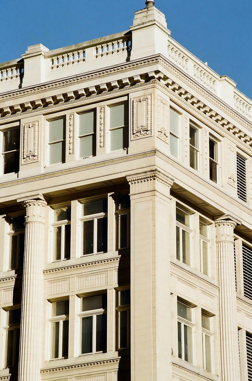 a tall white building with a clock on the top of it