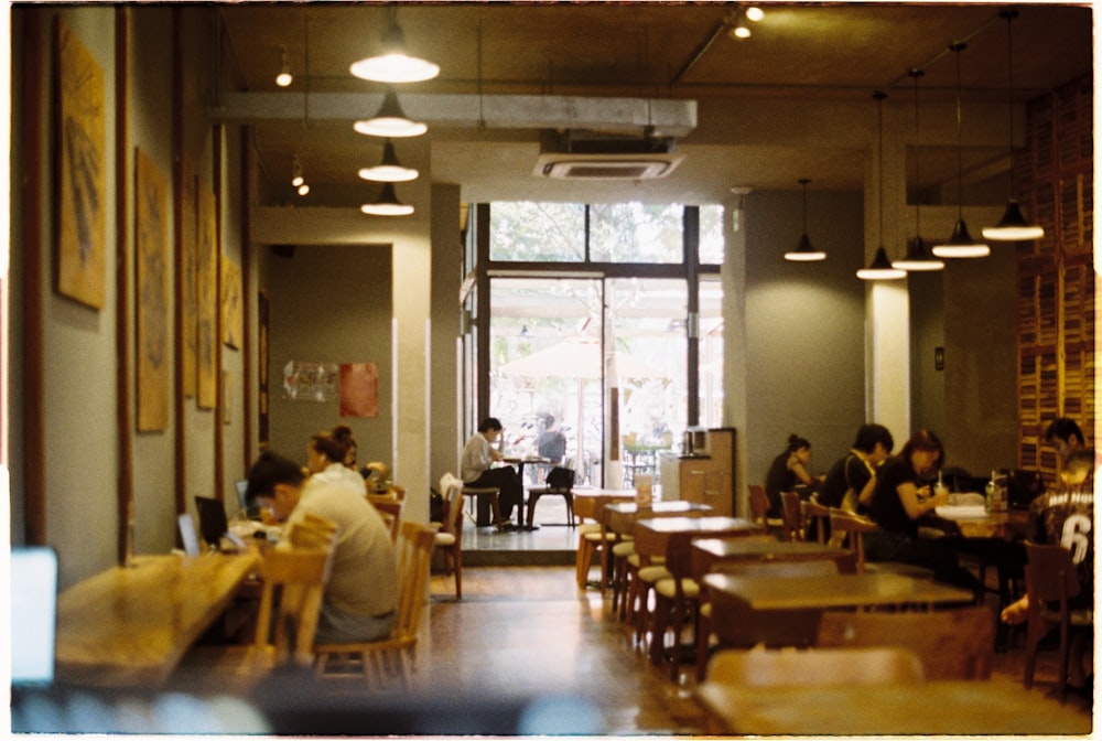 a group of people sitting at tables in a restaurant