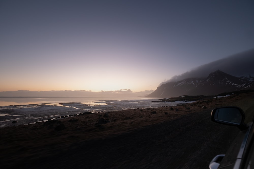 a car driving down a road next to the ocean