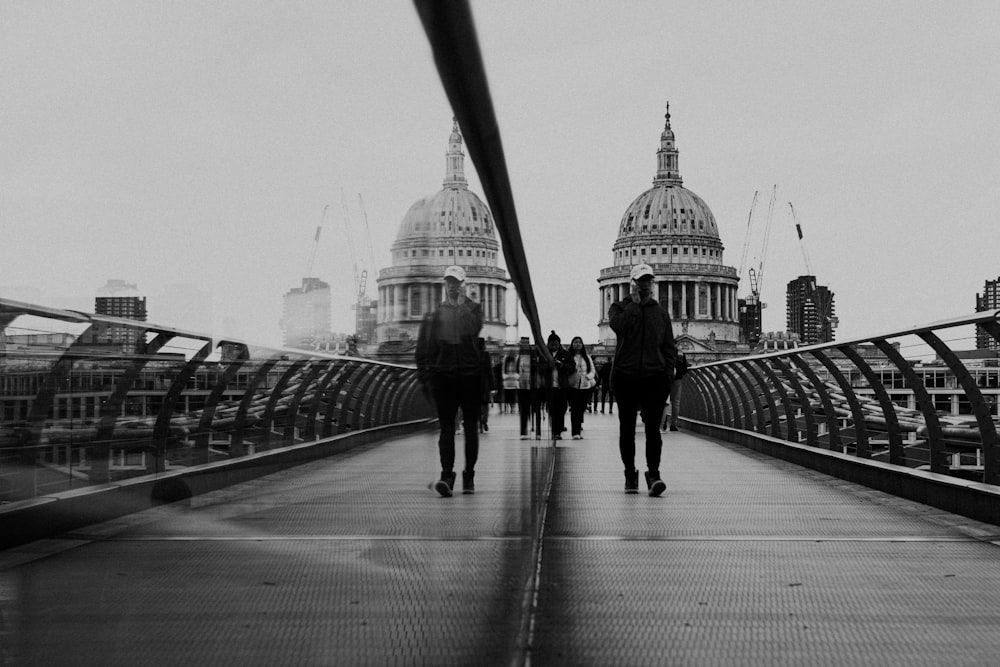 a group of people walking across a bridge