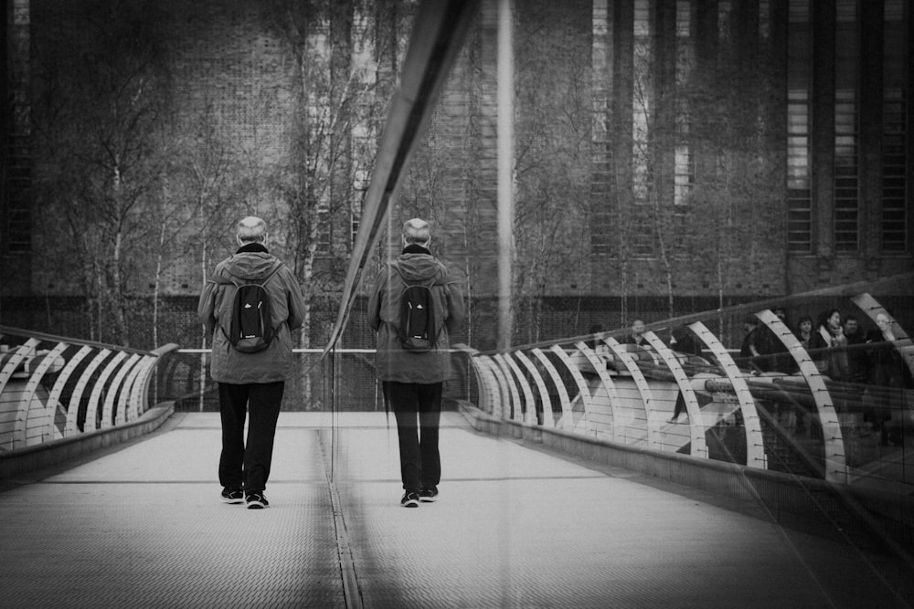 a couple of people walking across a bridge