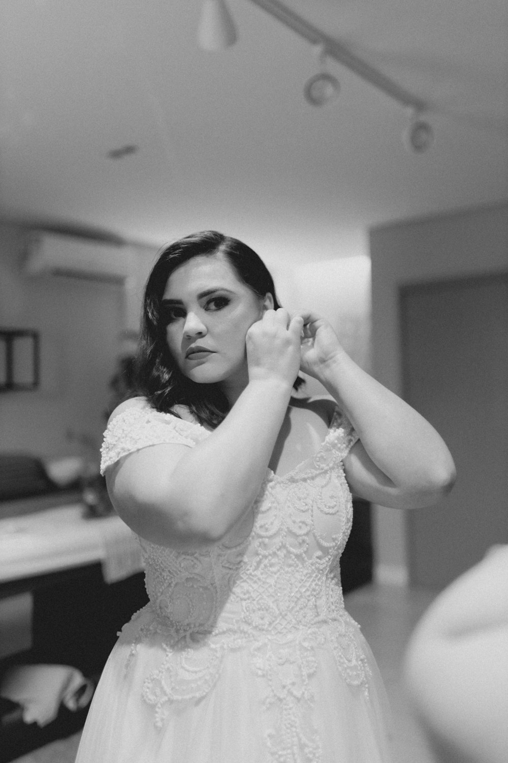 a woman in a wedding dress adjusting her hair