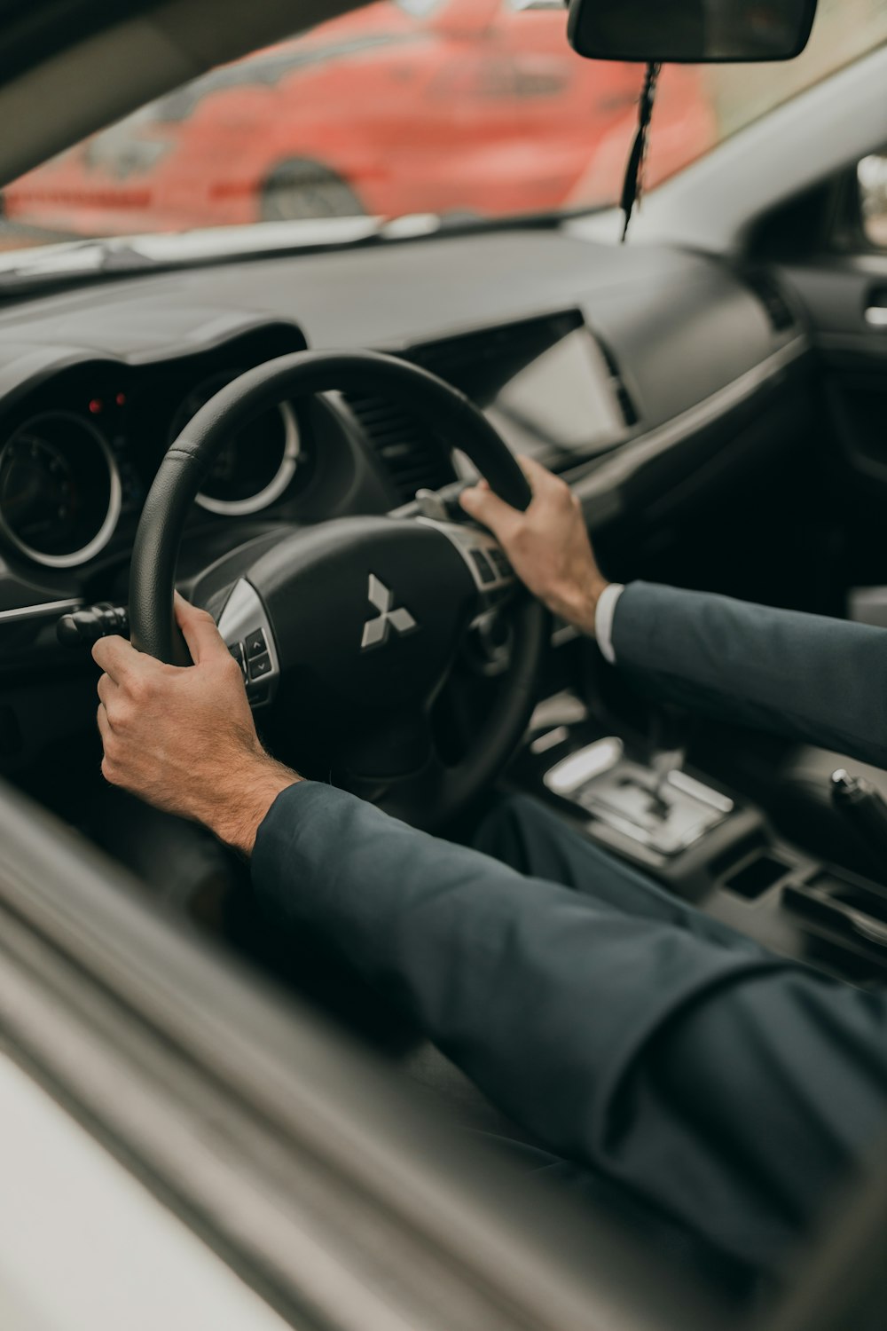 a man driving a car with his hands on the steering wheel