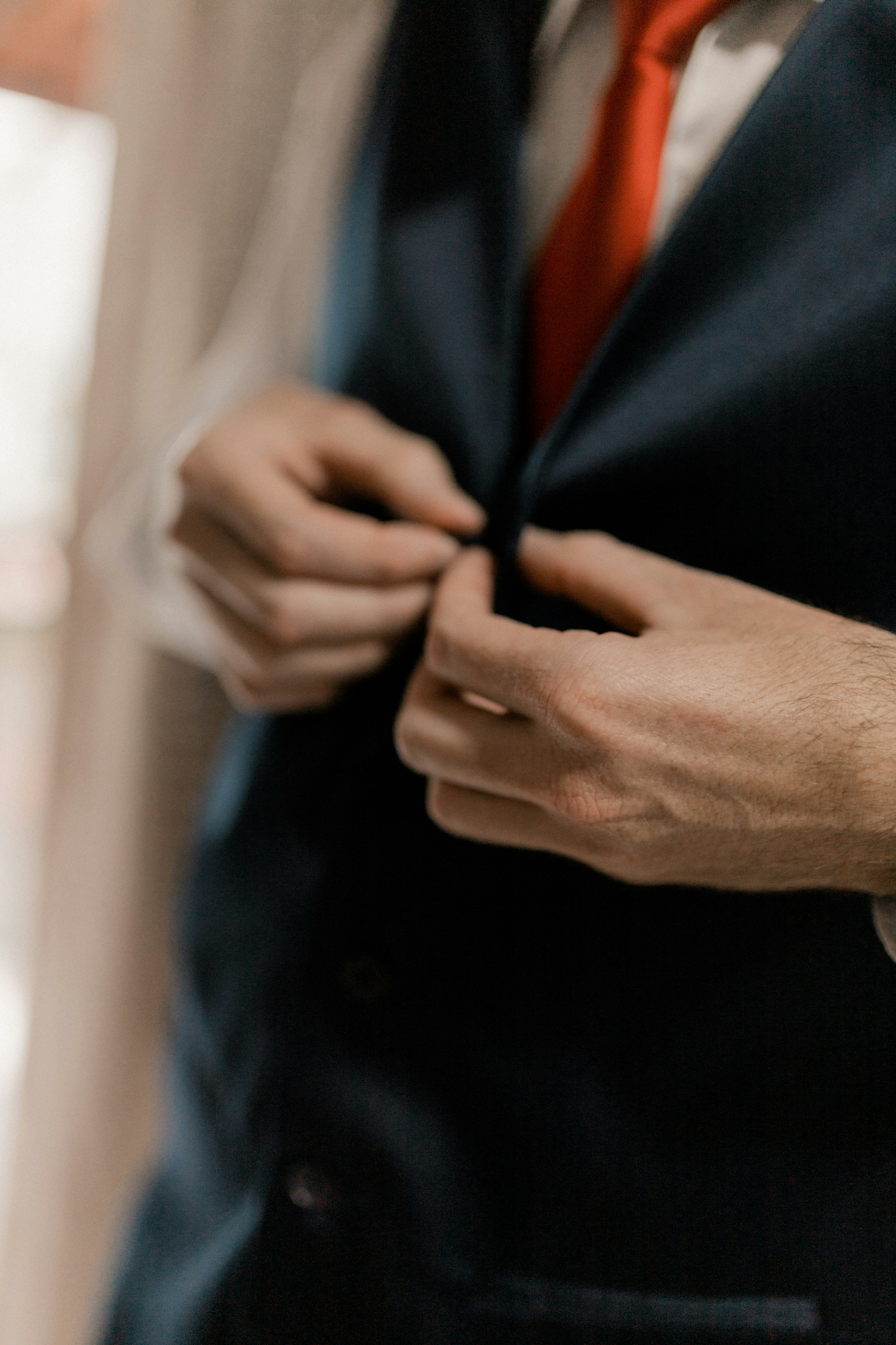 a man wearing an orange tie and a black suit