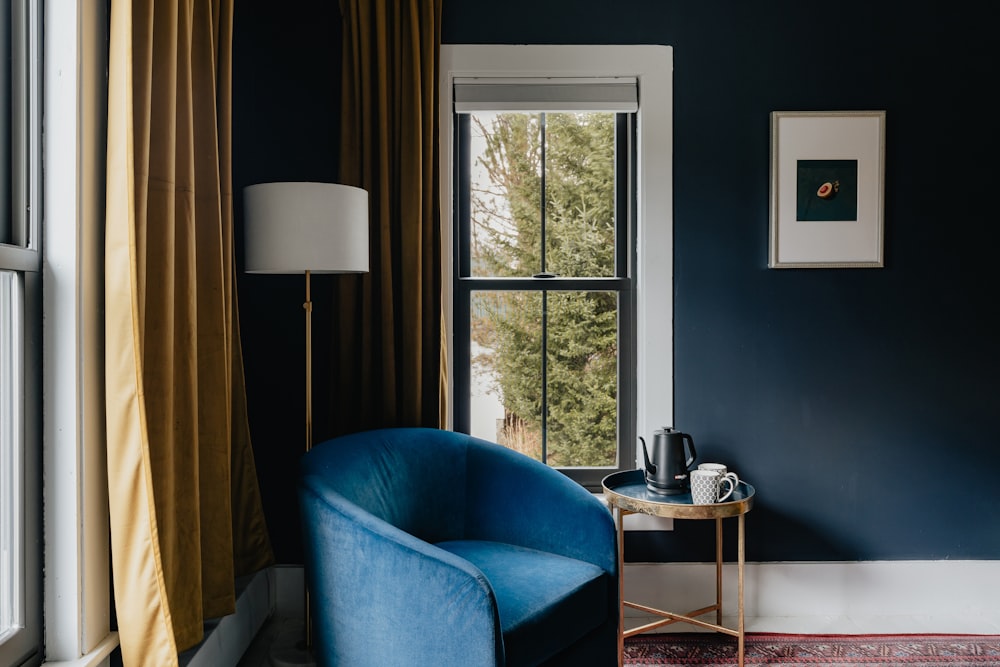 a blue chair sitting in front of a window