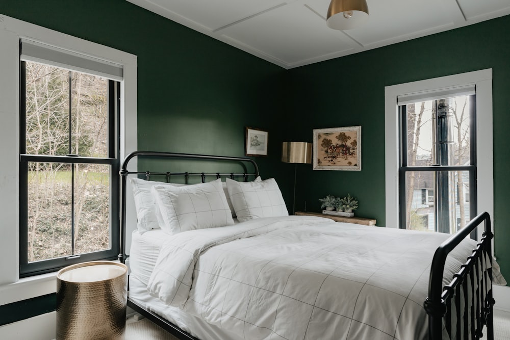 a bedroom with green walls and white bedding