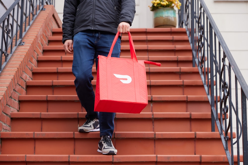 male walking down the steps with DoorDash bag