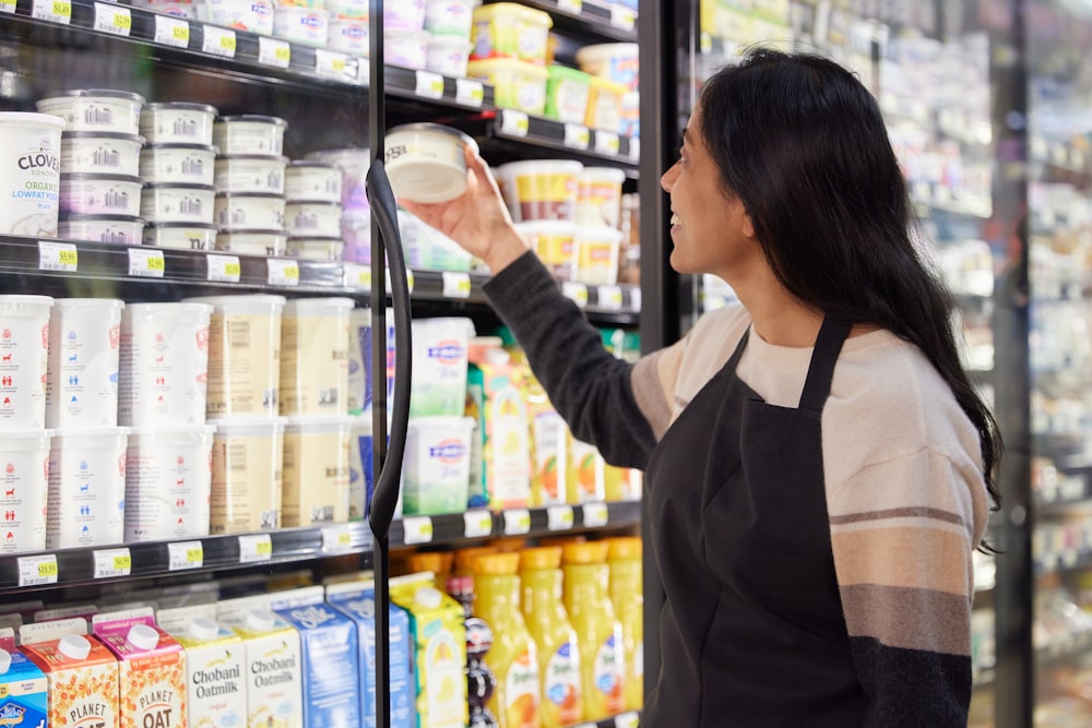 Donna che sfoglia i prodotti refrigerati in negozio