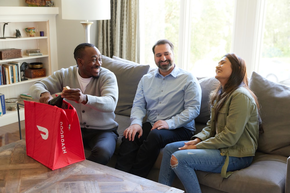 Eine Gruppe von Freunden lacht, während sie Wein aus der DoorDash-Tasche auspacken