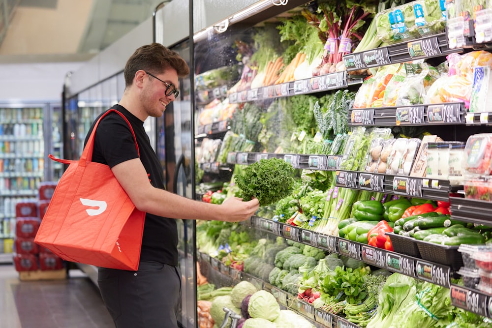 Männchen stöbert mit DoorDash-Tasche im Geschäft nach frischen Produkten