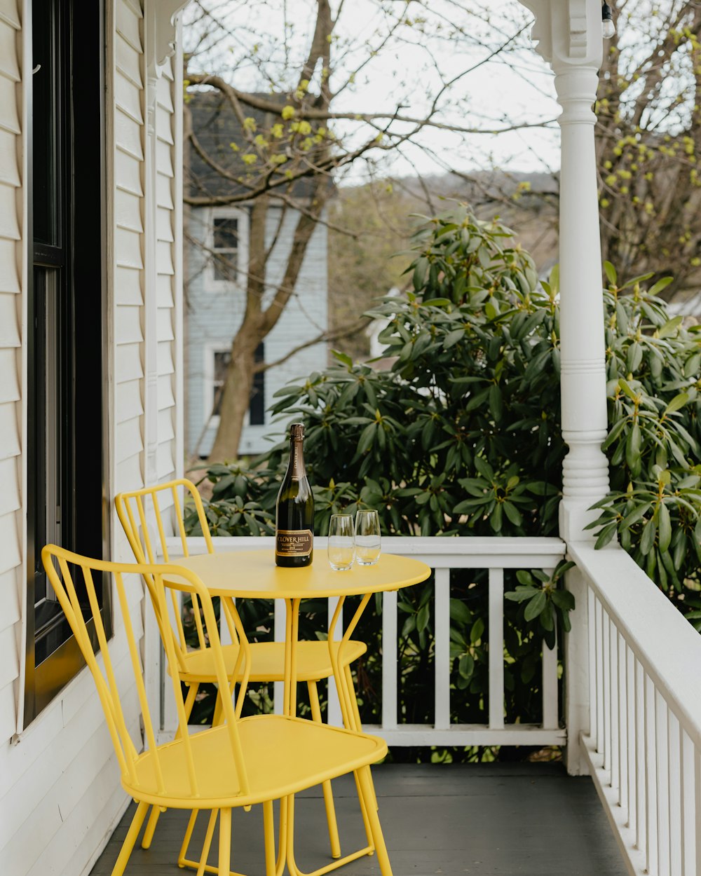 a yellow table and chairs on a porch