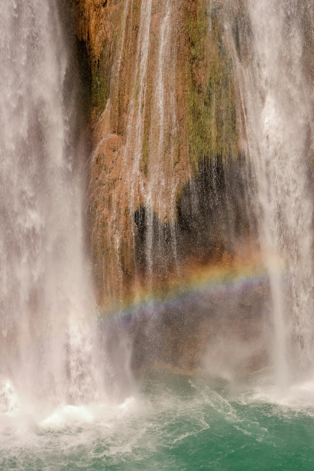 a waterfall with a rainbow in the middle of it