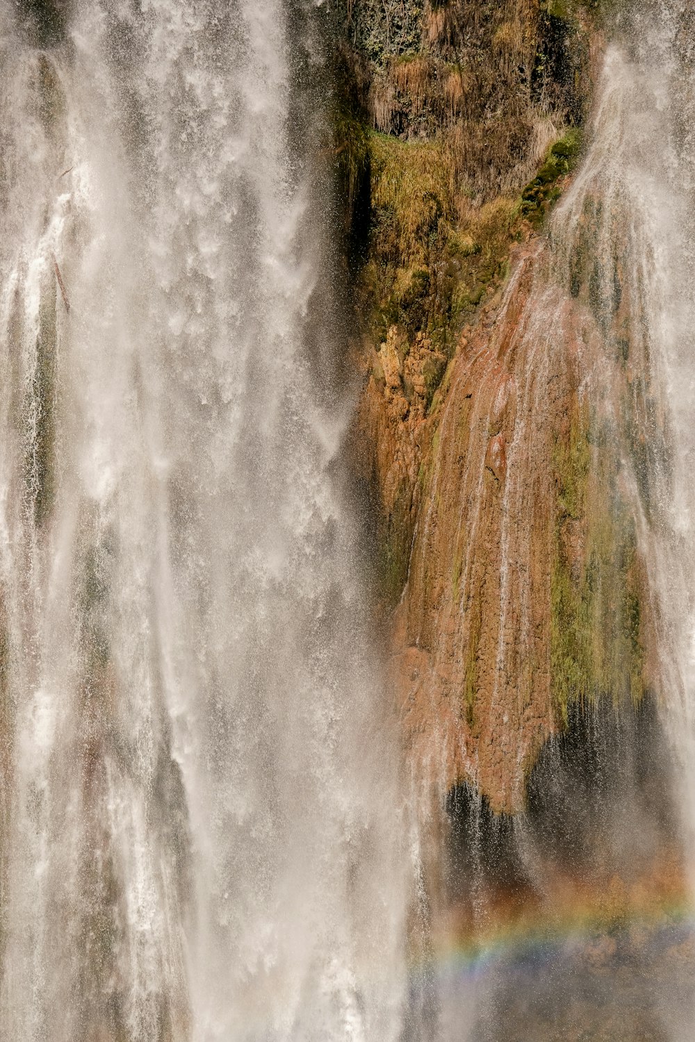 a waterfall with a rainbow in the middle of it