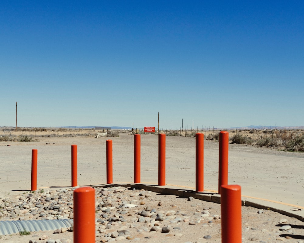 there are many orange poles in the middle of the desert