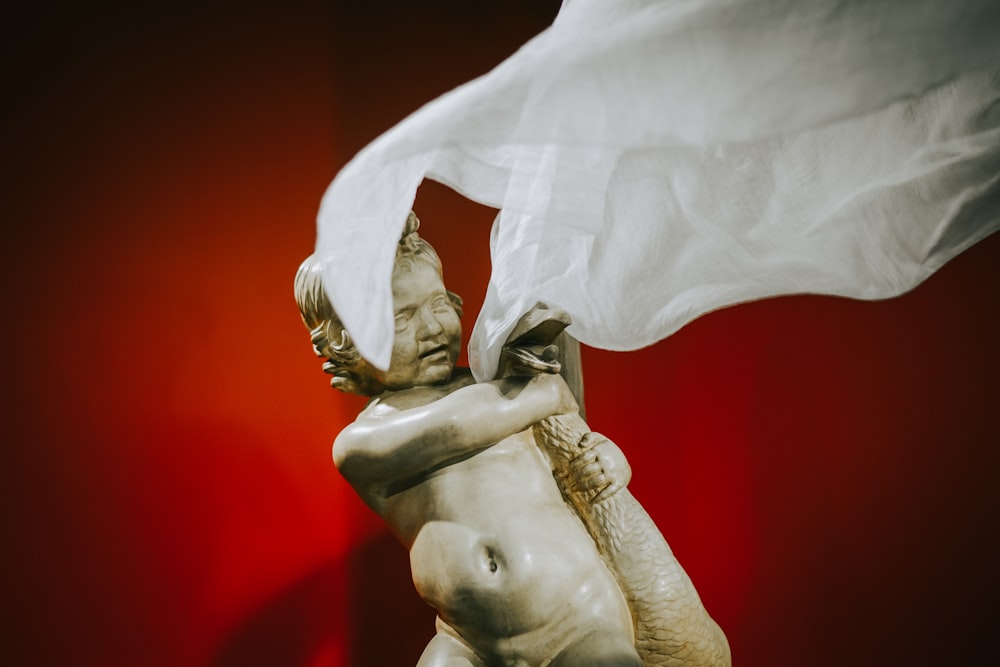 una statua di un uomo che tiene in mano un panno bianco